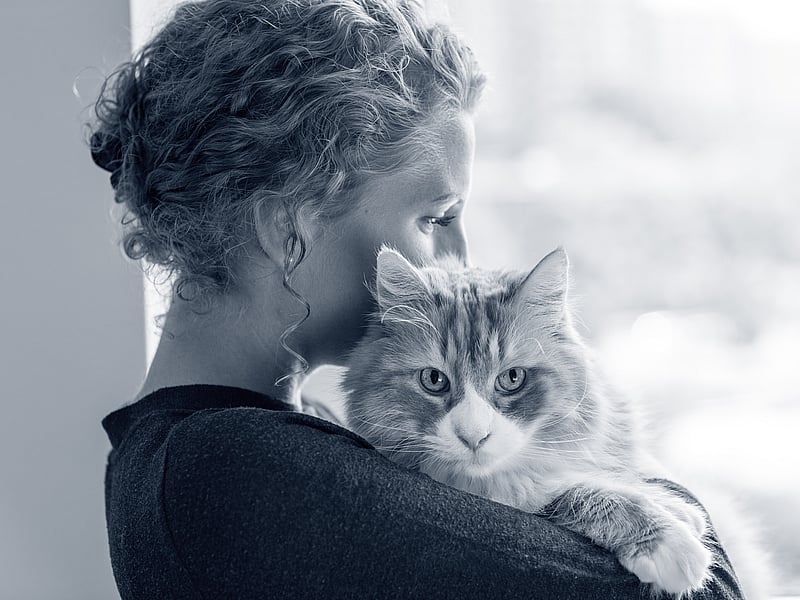 Kvinna håller om en katt.