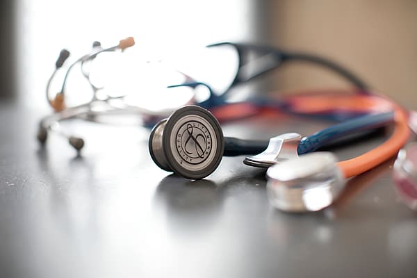 Två stetoskoper ligger på ett bord.