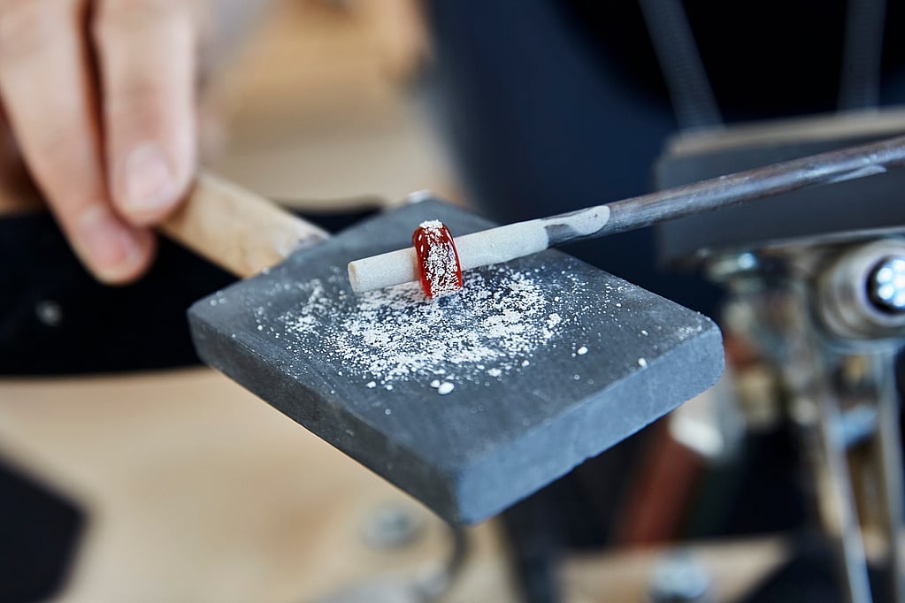 En person som håller i en metallbit med en röd ring på.